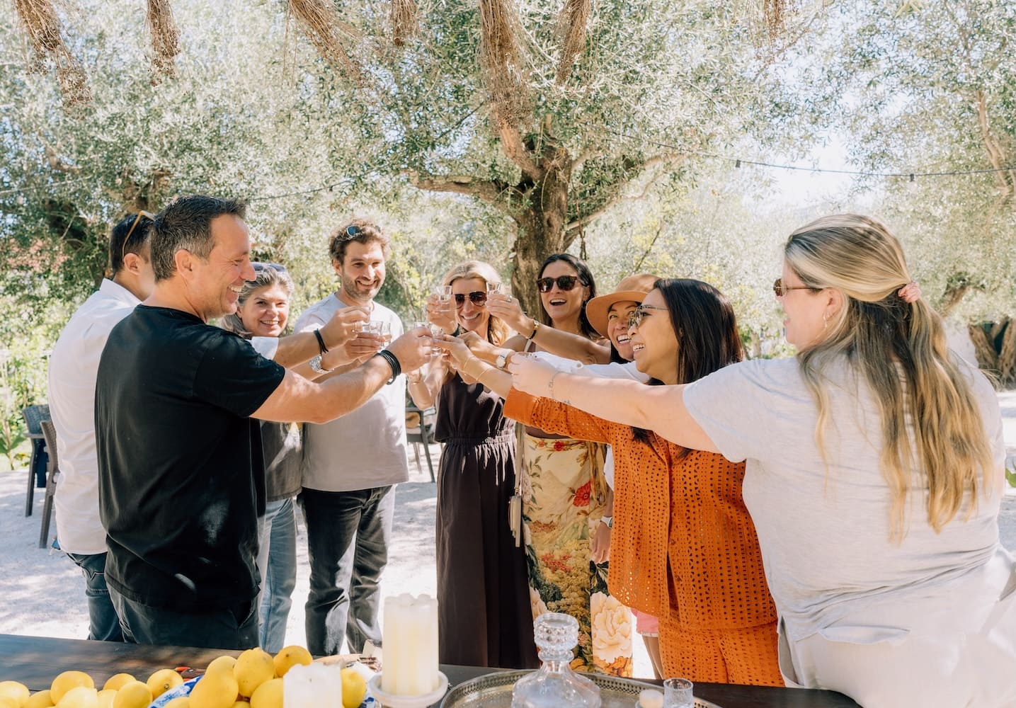 Guests enjoying a Corfiot meal beneath the olive trees at Rose Garden Corfu